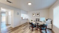 Located in Sacramento, CA (95821), this well-maintained single-floor space offers a cohesive, modern aesthetic defined by light wood-look flooring that runs seamlessly throughout. The layout, as revealed by the dollhouse view, is thoughtfully organized into distinct functional zones.

The office area is a standout feature, equipped with a spacious work desk, ergonomic seating, and guest chairs, making it well-suited for professional use. A pass-through window connects this area to an adjacent sink, adding a convenient utility element. Framed artwork on the crisp white walls adds a touch of polish.

The galley-style kitchen is efficiently designed, featuring white cabinetry on both sides, white appliances including a range and dishwasher, a stainless steel sink, and light countertops. A window at the end of the kitchen allows natural light to brighten the space.

A welcoming entry area provides a functional reception-style zone with wall-mounted hooks, a compact desk, and natural light filtering through a side window. The full bathroom is clean and straightforward, outfitted with a shower/tub combo and wood-look flooring consistent with the rest of the space.

An additional bright room features a sliding glass door that opens to a fenced outdoor area, allowing natural light to pour in and offering a refreshing connection to the exterior.