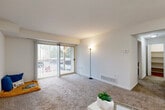 Located at 22250 Swan St in South Lyon, Michigan, this one-bedroom, one-bathroom unit offers a well-designed single-floor layout that makes efficient use of its space. The living room serves as the heart of the unit, featuring plush carpeting, neutral walls, and a sliding glass door with vertical blinds that opens to a private balcony, allowing an abundance of natural light and outdoor views to flow in. An adjacent dining area provides a seamless transition between the living and kitchen spaces. The galley-style kitchen is outfitted with rich, warm-toned cabinetry, granite-look countertops, a stainless steel sink, and wood-look flooring, offering a functional and attractive cooking environment with ample storage. The bedroom is a comfortable retreat, carpeted throughout, with a large window fitted with vertical blinds that brings in natural light. A full-panel bifold closet provides generous storage. The bathroom features a wood-toned vanity with a white countertop, a framed mirror, tiled flooring, and a shower-tub combination. A hallway connects the key spaces, and an additional closet enhances overall storage capacity. The unit's clean, neutral palette and functional layout make it a practical and inviting living space.
