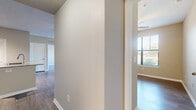 This single-floor unit offers a functional and thoughtfully arranged layout across two bedrooms and two bathrooms. The combined kitchen and living area serves as the heart of the space, featuring hardwood-style flooring that extends throughout. The kitchen is equipped with dark espresso cabinetry, granite countertops, a tile backsplash, stainless steel appliances, and a central island with a built-in sink, providing ample workspace and storage. Track lighting overhead ensures the area is well-lit. The living room benefits from large windows fitted with horizontal blinds and a glass-panel exterior door, allowing abundant natural light and outdoor access. Crown molding and a ceiling fan add a polished finish to the room.

The primary bedroom is a comfortable, well-proportioned space with its own window and ceiling fan. The second bedroom mirrors this layout with similar flooring and a window with outdoor views. A hallway connects the private areas of the unit, which include a dedicated closet for additional storage. Both bathrooms feature granite-topped vanities, dark cabinetry, and tiled tub-shower combinations with wood-style flooring, maintaining a consistent design aesthetic throughout the unit.