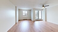 This 710 square foot apartment in St. Catharines, ON offers a well-designed living space with two bedrooms and one bathroom. The unit features a consistent aesthetic throughout, with crisp white walls and warm hardwood flooring creating a bright, inviting atmosphere. The primary bedroom, measuring 130 square feet, provides ample space for a comfortable retreat.

The living area is open and airy, benefiting from natural light through large windows. A ceiling fan adds both style and functionality. The kitchen, while compact, is efficiently designed and opens to the main living space, promoting a sense of openness. The bathroom is modern and functional, featuring a full-size bathtub with a curved shower rod and neutral tiled walls.

Storage solutions are integrated throughout, with closets featuring sliding doors to maximize space. The apartment also includes in-unit laundry facilities, adding convenience to daily life. A standout feature is the balcony, offering picturesque winter views of snow-covered trees and the surrounding neighborhood.

The property's location at 128 St Augustine Dr provides residents with a serene setting while maintaining easy access to local amenities. This well-maintained apartment combines comfort and practicality, making efficient use of its 710 square feet to create a cozy yet functional living environment.