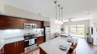 This well-appointed one-bedroom, one-bathroom residence in Cedar Park, TX offers a smart, open-concept layout that maximizes every square foot. The kitchen is a standout centerpiece, featuring rich dark wood cabinetry, granite countertops, a subway tile backsplash, full stainless steel appliances, and a spacious island with seating for two — all illuminated by elegant pendant lighting. The kitchen flows seamlessly into the living area, which boasts warm hardwood flooring, soaring ceilings, and a ceiling fan. French doors open to a private balcony overlooking lush, open natural scenery, flooding the space with natural light. The bedroom offers plush carpeting and direct access to a walk-in closet with built-in shelving, providing ample storage. The full bathroom is finished with matching granite countertops, dark wood cabinetry, a large vanity mirror, a soaking tub with tile surround, and hardwood-style flooring. A hallway connects the main living areas efficiently, contributing to the cohesive flow of the floor plan. Throughout the residence, neutral tones and consistent finishes create a clean, modern aesthetic that is both functional and inviting.