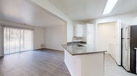 This well-maintained single-floor residence offers a bright, modern interior designed with a cohesive aesthetic throughout. Light wood-style flooring runs continuously across all rooms, complemented by crisp white walls and clean white baseboards that create a fresh, airy atmosphere.

The open-concept kitchen is a central highlight, featuring a peninsula island with a granite-style countertop and stainless steel sink, white shaker-style cabinetry, and a full suite of stainless steel appliances including a refrigerator, electric range, over-the-range microwave, and generous counter space. The kitchen opens directly into a spacious living area, enhancing the sense of flow and connectivity. A sliding door provides access to the exterior, bringing in additional natural light.

The bedrooms are well-proportioned, each featuring wood-style flooring, white walls, and window blinds that allow for natural light while maintaining privacy. One bedroom includes a closet with double doors for added storage convenience.

Two full bathrooms are included, each featuring a tub-shower combination, toilet, and neutral finishes. One bathroom includes a granite-style vanity countertop, white cabinetry, and a large mirror, adding a polished touch.

A dedicated in-unit laundry room houses a full-size washer and dryer with an overhead shelf, offering practical everyday convenience. The entry area is clean and welcoming, completing this move-in-ready residence.