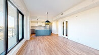 Located at 600 Mountaineer Private in Ottawa, this well-appointed 2-bedroom, 2-bathroom unit offers a thoughtfully designed single-floor layout. The open-concept living, dining, and kitchen area serves as the heart of the home, featuring light-toned hardwood flooring throughout and a clean, modern aesthetic with crisp white walls and ceilings.

The kitchen is a standout, showcasing a striking teal-blue island with a white countertop, pendant lighting, stainless steel appliances including a french-door refrigerator and range, a tile backsplash, and a combination of white upper and grey lower cabinetry. Large floor-to-ceiling windows flood the living area with natural light and provide open views of the surrounding Ottawa cityscape, with access to a balcony.

The two bedrooms are bright and well-proportioned, with hardwood flooring, ample closet space including sliding-door wardrobes, and large windows. The primary bedroom offers generous space and serene views.

Both bathrooms are finished to a modern standard; one features a sleek walk-in glass shower with large-format white tiles, a built-in niche, and chrome fixtures. Additional conveniences include in-unit laundry, a pantry, and multiple closets. The hallways are clean and well-lit with recessed lighting, completing this polished and functional home.