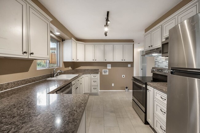 Building Photo - 4 Bedroom Home with Covered Parking & Fenced Backyard