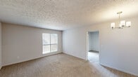 Located at 5801 E Shirley Ln in Montgomery, Alabama, this single-floor, one-bedroom, one-bathroom unit offers a well-organized layout with functional living spaces throughout. The generously sized bedroom features soft wall-to-wall carpeting, recessed lighting, and a mirrored sliding-door closet that adds depth to the room. A sliding glass door opens directly to a private balcony, filling the space with natural light and providing outdoor access. The kitchen is efficiently designed with rich, warm-toned wood cabinetry, light countertops, and stainless steel appliances including an electric range, built-in microwave, and dishwasher. Wood-look flooring runs through the kitchen, which also features a peninsula counter — ideal for casual dining or additional prep space. The bathroom includes a wide vanity with ample counter space, wood cabinetry below, a large wall mirror, and a well-lit fixture above the sink. Textured ceilings are present throughout, complementing the neutral wall tones that give the unit a clean, move-in-ready feel. The thoughtful layout and practical finishes make this unit a comfortable and well-appointed living space in the heart of Montgomery.