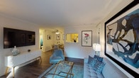 This single-floor residence offers a thoughtfully designed layout that balances comfort and functionality across its key living spaces. The living room serves as the centerpiece of the home, highlighted by a white-mantled fireplace flanked by framed artwork, rich wood-look flooring, crown molding, and a sliding glass door that opens to a private balcony with outdoor views. The space flows naturally into a dedicated dining area, which features a ceiling fan and hardwood-style flooring, creating an intimate setting for meals. A pass-through window connects the dining area to the galley-style kitchen, which is equipped with light wood cabinetry, white countertops, stainless steel appliances including a refrigerator, electric range, and built-in microwave, providing ample storage and workspace. The two bedrooms are carpeted and generously sized, each offering ample closet space — one with mirrored sliding doors and another with an open shelving system. Both rooms are served by a full bathroom featuring a tub-shower combination. Throughout the home, neutral tones, crown molding in the main living areas, and consistent flooring choices create a cohesive and welcoming ambiance suited to a variety of lifestyles.