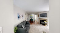 Located at 7303 Bryn Athyn Way in Raleigh, NC, this single-floor, 2-bedroom, 2-bathroom residence offers a thoughtfully laid-out living space with a clean, neutral aesthetic throughout. The living room is a welcoming retreat, featuring plush carpet, a tiled fireplace with a wall-mounted TV above, and a sliding glass door with vertical blinds that invites natural light and provides outdoor access. The kitchen is well-equipped with warm oak cabinetry, dark countertops, stainless steel appliances including a refrigerator and dishwasher, and hardwood-style flooring, complemented by a window that brightens the workspace. Both bedrooms are generously sized, each featuring soft carpet, ceiling fans with light fixtures, and ample natural light. The primary bedroom includes a walk-in closet with built-in shelving for organized storage. A second closet serves the additional bedroom. The two full bathrooms each offer a tub-shower combination, with one featuring wood-style flooring and a vanity with oak cabinetry. A connecting hallway ties the layout together efficiently. The overall ambiance is bright, neutral, and move-in ready, offering a comfortable and functional home in a convenient Raleigh location.