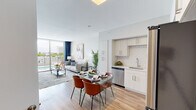 Located at 110 NW 1st St in the heart of downtown Miami, this third-floor unit offers a well-designed, single-level layout with a clean, contemporary aesthetic throughout. The open-concept living, dining, and kitchen area forms the core of the space, bathed in natural light from large sliding glass doors that lead to a private balcony. From the balcony, residents enjoy unobstructed views of a pool area and surrounding Miami skyline, creating an inviting indoor-outdoor connection.

The kitchen is thoughtfully appointed with white shaker-style cabinetry, a classic white subway tile backsplash, light quartz countertops, a stainless steel sink, and a full suite of stainless steel appliances including a refrigerator, range, microwave, and dishwasher. Wood-style flooring runs throughout the main living areas, adding warmth to the neutral color palette.

The living area is generously proportioned and flows seamlessly into the dining space, making the layout practical for both daily living and entertaining. The bedroom is comfortably sized with a sliding window offering natural light and city views, complemented by soft neutral tones. The bathroom features a soaking tub and shower combination with tile surround, a vanity, and light porcelain tile flooring.