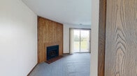 Located in West Middlesex, PA, this well-laid-out 2-bedroom, 2-bathroom single-floor home offers a practical and comfortable living arrangement. The living room serves as the focal point of the home, highlighted by a striking floor-to-ceiling wood-paneled fireplace surround with a tiled hearth and plush carpeting underfoot. A sliding glass door provides access to the outdoors, filling the space with natural light. The kitchen is efficiently designed with warm oak cabinetry, laminate countertops, and a full suite of black appliances including a refrigerator, electric range, and dishwasher, complemented by durable wood-look flooring. Both bedrooms are carpeted and bathed in natural light through windows with outdoor views. The primary bedroom is a comfortable size and features dual sliding wood-panel closet doors, offering generous storage. The second bedroom connects conveniently to additional hallway space and a closet. The two bathrooms are clean and functional — one features a white vanity with a medicine cabinet mirror, while the other includes a tub-shower combination. Warm wood-toned trim and doors are consistent throughout, giving the home a cohesive, classic aesthetic. A dedicated entrance, hallway, and in-unit closet round out this thoughtfully organized home.
