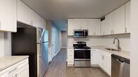 Located at 514 Bridge Ave in Forest Park, Georgia, this single-floor home has been thoughtfully updated with contemporary finishes and a clean, cohesive design. The interior is unified by durable wood-look flooring and a neutral gray color palette that extends throughout every room, creating a calm and modern atmosphere.

The kitchen is a standout feature, showcasing crisp white shaker-style cabinetry extending to the ceiling for generous storage, light stone-look countertops, and a full suite of stainless steel appliances including a refrigerator, electric range, over-the-range microwave, and dishwasher. A window in the adjacent dining area brings in natural light and connects the kitchen to the rest of the living space.

The open living area is well-proportioned, with recessed lighting and multiple vents indicating a central HVAC system for year-round comfort. The bedrooms are generously sized, each featuring ceiling fans with integrated lighting, wood-look flooring, and closets for ample storage. The rooms offer a clean, move-in-ready feel with consistent gray-toned walls and bright white trim throughout.

Overall, this home presents a well-maintained, updated living environment with modern conveniences and a cohesive design aesthetic, ideally situated in the Forest Park community.