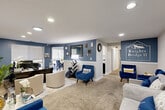 The Knightsbridge Apartments leasing office at 13516 Greencastle Ridge Terrace in Burtonsville, Maryland, is a well-appointed, single-floor community hub designed to welcome and serve residents and prospective tenants alike. The space is unified by a cohesive blue and neutral color palette, plush carpeting, and recessed lighting throughout.

The main reception and lounge area greets visitors with an open, comfortable layout featuring bold blue accent walls with white chair-rail wainscoting, multiple seating arrangements with blue velvet and cream upholstered chairs, and a decorative area rug. This space flows naturally into a private leasing office, where a large executive desk, leather seating, wall-mounted artwork, and a window overlooking greenery create a professional yet inviting atmosphere for consultations.

A dedicated break room and kitchen features white shaker cabinetry, granite-look countertops, a subway tile backsplash, full appliances including a range and microwave, and a small dining area with natural light and wooded views. A relaxed lounge room with motivational wall art, a neutral sofa, and blue accent chair provides an additional comfortable retreat. Two well-maintained bathrooms with large vanity mirrors and modern fixtures round out the functional amenities of this thoughtfully designed leasing office.
