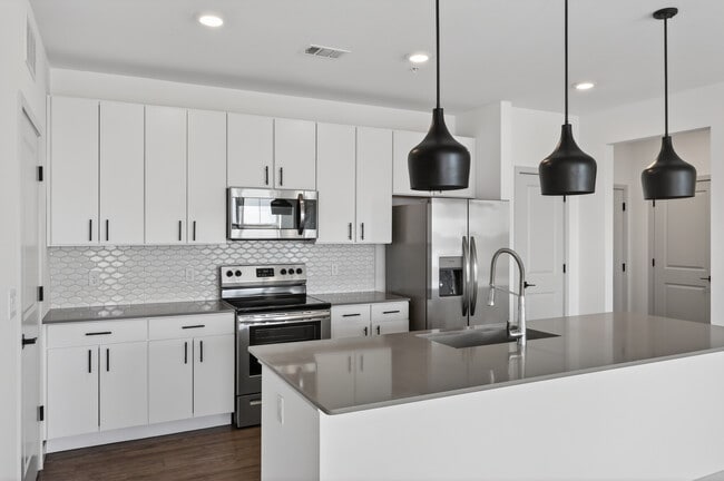 Cook, dine, and gather in a stylish kitchen space. - Lofts at Highlands