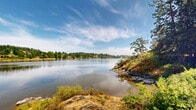 Located at 3037 Craigowan Rd in View Royal, British Columbia, this single-level property offers a remarkable natural setting defined by its direct waterfront access and sweeping views of a calm, reflective inlet. The landscape is characterized by dramatic exposed rock outcroppings that rise naturally from the shoreline, framed by mature Garry oaks, towering conifers, and native coastal vegetation — all set beneath expansive, open skies that shift beautifully throughout the day.

The property's outdoor space is thoughtfully cultivated, featuring a well-established garden area with raised planting beds, ornamental plantings, lawn space, and seating areas that invite outdoor relaxation. Latticed structures and trellises add a charming, organized character to the garden, while the surrounding mature trees provide natural privacy and shade.

The waterfront edge is defined by natural stone and rocky terrain that descends gently toward the water, offering unobstructed sightlines across the inlet to the forested hillsides and residential shores beyond. The combination of serene water reflections, native rock, and lush greenery creates a tranquil, nature-immersed ambiance throughout the property. This is a distinctive outdoor environment that captures the essence of coastal British Columbia living.