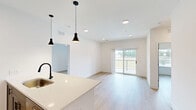This well-appointed 2-bedroom, 2-bathroom residence in Dardenne Prairie, MO offers a thoughtfully designed single-floor layout with modern finishes throughout. Light hardwood-style flooring flows seamlessly across the entire living space, creating a bright and cohesive aesthetic.

The kitchen serves as a focal point, featuring sleek gray shaker cabinetry extending to the ceiling, a classic subway tile backsplash, and a full suite of stainless steel Whirlpool appliances including a refrigerator, electric range, and built-in microwave. A central island with a white quartz countertop, matte black pendant lighting, and an undermount sink adds both style and functionality.

The spacious primary bedroom includes a ceiling fan, a walk-in closet with wire shelving, and direct access to a private en-suite bathroom. Both bathrooms are finished with large-format marble-look tile surrounding soaking tub-shower combinations and warm wood-look flooring. The second bedroom benefits from natural light through a window with outdoor views and is also equipped with a ceiling fan.

A dedicated laundry room houses a stacked Whirlpool washer and dryer unit. The living area opens to a balcony through sliding glass doors, offering views of the surrounding neighborhood. Clean white walls and recessed lighting complete the modern, move-in-ready feel of this residence.