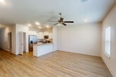 Located at 2754 Eula Rd in Biloxi, Mississippi, this two-story home offers a well-organized layout across two floors. The main level hosts an open-concept living and kitchen area finished with light hardwood-style flooring and recessed lighting. A ceiling fan adds comfort to the bright, airy living space, which is illuminated by natural light from multiple windows and a glass door. The kitchen is thoughtfully appointed with crisp white shaker cabinets, granite countertops, a breakfast bar peninsula, and a full suite of stainless steel appliances including a refrigerator with ice maker, electric range, microwave, and dishwasher. An attached garage with an automatic opener provides convenient interior access. Upstairs, the spacious primary bedroom features light hardwood-style flooring, a ceiling fan, and generous natural light. Two additional bedrooms are carpeted and offer comfortable proportions with natural light from windows. Three full bathrooms serve the home, including one with a soaking tub and shower combination with chrome fixtures. Clean white walls, panel-style doors, and consistent finishes throughout give the home a cohesive, move-in-ready feel.