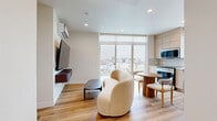 Located at 535 Glenrock Ave in the desirable Westwood neighborhood of Los Angeles, this modern 3-bedroom, 2-bathroom unit offers a thoughtfully designed single-floor layout with clean, contemporary finishes throughout. Light wood flooring flows seamlessly across the living areas, complementing the warm, neutral color palette that defines the space.

The kitchen is a standout feature, equipped with stainless steel appliances including a range, dishwasher, microwave, and refrigerator. Flat-front light wood cabinetry extends to the ceiling, providing ample storage, while a white quartz countertop and a textured tile backsplash complete the modern aesthetic. A window above the sink frames city views, filling the space with natural light.

The primary bedroom is generously sized and benefits from large windows that invite in natural light and offer neighborhood views. Built-in shelving and storage add functional character. The two additional bedrooms are well-proportioned, each with windows providing natural light and a clean, minimalist design.

Both bathrooms share a cohesive modern design, featuring terrazzo-style flooring, wall-mounted toilets, floating wood vanities with vessel sinks, illuminated medicine cabinet mirrors, and tiled soaking tubs with showers. A private balcony extends the living space outdoors, ideal for enjoying the Southern California climate.