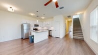 Located at 8011 Allure Cir in Orange City, FL, this two-story home offers a thoughtfully designed layout spread across two floors. The main level features an open-concept living and dining area with wood-look flooring, ceiling fans, and large windows that fill the space with natural light. A staircase connects the floors, adding a classic architectural element to the layout. The kitchen is a standout feature, showcasing white shaker cabinetry, a subway tile backsplash, granite countertops, a center island, stainless steel appliances, and pendant lighting — a well-appointed space ideal for cooking and entertaining. A pantry adds convenient storage nearby. The main floor also includes an attached garage with an automatic opener and a dedicated laundry closet housing a full-size washer and dryer. Upstairs, three carpeted bedrooms offer comfortable retreats, each with ceiling fans and closets. The generously sized primary bedroom provides a peaceful sanctuary. Four bathrooms are distributed throughout the home, including one with a glass-enclosed walk-in shower and tile surround. Clean, neutral finishes and a bright, airy palette give the entire home a fresh, move-in ready feel.