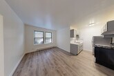 Located at 5726 N Winthrop Ave in Chicago's vibrant Edgewater neighborhood, this one-bedroom, one-bathroom unit offers a well-designed layout with modern updates throughout. The combined living and dining area greets you with warm hardwood-style flooring, crisp white walls, and a window that invites natural light into the space. A baseboard heating system runs along the perimeter, ensuring comfort year-round. The galley-style kitchen is thoughtfully appointed with gray shaker cabinets, a light quartz countertop, stainless steel appliances including a refrigerator and electric range, a stainless steel sink, and a decorative subway tile backsplash with an accent mosaic border — providing both style and practicality. A hallway connects the main living area to the private bedroom, which features a ceiling fan with light fixture, a window, baseboard heating, and two generous closets with bifold doors, offering ample storage. The full bathroom is finished with classic white subway tile surrounding the tub and shower, a white vanity, and polished chrome fixtures, creating a clean and timeless aesthetic. With two closets and a dedicated hallway, this unit maximizes every inch of its compact footprint efficiently.