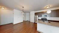 This single-level, two-bedroom, two-bathroom unit offers a thoughtfully designed layout across a comfortable footprint. The open-concept kitchen and living area serves as the heart of the home, featuring rich hardwood-style flooring, a large granite-topped island with an undermount sink, and pendant lighting overhead. The kitchen is equipped with stainless steel appliances—including a refrigerator, range, and microwave—complemented by dark espresso cabinetry and a classic white subway tile backsplash.

The primary bedroom is a well-sized retreat, featuring hardwood-style flooring, a ceiling fan, and a sliding glass door with vertical blinds that allows natural light to fill the space. The second bedroom offers plush carpeting, a ceiling fan with light fixture, and a window with blinds. Both bathrooms are finished consistently, with dark cabinetry, granite countertops, hardwood-style flooring, and a tub-shower combination with tile surround.

A dedicated laundry room houses a stacked washer and dryer unit, adding everyday convenience. The overall design is cohesive, with neutral tones, consistent finishes, and a clean, modern aesthetic throughout.