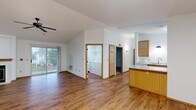 Located at 2128 Meadowland Dr in Sheboygan, Wisconsin, this well-appointed 2-bedroom, 3-bathroom single-floor home offers a thoughtful layout with a range of comfortable living spaces. The open living room is a standout, featuring soaring vaulted ceilings, warm hardwood flooring, a ceiling fan, a wood-trimmed fireplace, and a sliding glass door that invites natural light and outdoor views. The kitchen is efficiently designed with warm oak cabinetry, granite-look countertops, a breakfast bar peninsula, white appliances including an electric range and refrigerator, and a double sink — all complemented by hardwood flooring. A dedicated utility room houses in-unit washer and dryer hookups for added convenience. The spacious primary bedroom offers plush carpeting, vaulted ceilings, and a generous closet, while the second bedroom features carpet, a large window with neighborhood views, and ample space. The three bathrooms include a luxurious primary bath with a large jetted soaking tub and wall mirror. Additional highlights include a chandelier-lit secondary room area, wood-trimmed interior doors throughout, and a closet for extra storage. The home's clean, neutral palette creates a bright and inviting ambiance throughout.