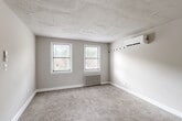 Located at 4012 38th St in Brentwood, MD, this one-bedroom, one-bathroom unit offers a well-organized single-floor layout with a variety of functional living spaces. The living room is generously sized with soft carpeting, neutral gray walls, and white-trimmed doors leading to multiple closets, providing ample storage throughout. A separate dining area adds versatility to the floor plan, while a connecting hallway links the key living spaces seamlessly.

The kitchen features a classic galley-style design with warm wood cabinetry, white countertops, hardwood-style flooring, and a natural light source from a side window. It is equipped with a gas range and a full-size refrigerator, with a cast-iron radiator providing supplemental heat.

The bedroom is a comfortable, well-lit retreat with dual windows that invite natural light and offer views of the surrounding neighborhood. It includes two closets, plush carpeting, a wall-mounted air conditioning unit, and a radiator for year-round climate control.

The bathroom is finished with white tile wainscoting, earthy stone-toned floor tiles, a wood-toned vanity with a stone-look countertop, and a window for natural ventilation. Radiator heating is present here as well, reinforcing the consistent warmth found throughout this charming unit.