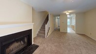 Located at 501 Audubon Lake Dr in Durham, NC, this multi-level property spans three floors and offers a well-organized layout with consistent finishes throughout. The interior features warm, neutral-toned walls paired with plush wall-to-wall carpeting across the living areas and bedrooms, creating a cohesive and comfortable atmosphere.

The kitchen is equipped with light wood cabinetry, a coil-burner electric range, and a full-size refrigerator, with tile flooring and a window providing natural light. The spacious main living area is bright and open, featuring ceiling fans with light fixtures and textured ceilings that add visual interest.

Bedrooms are generously sized, each with soft carpeting, ceiling fans, and large windows fitted with blinds that allow for ample natural light and views of the surrounding greenery. Several bedrooms also include closet access for added storage. Upper-floor hallways feature white-railed staircase banisters and connect rooms with easy flow.

Bathrooms are finished with tile flooring, wood-toned vanity cabinetry, and white countertops. Both tub/shower combinations and separate shower stalls are present, offering practical functionality. The 3D model reveals a staircase system connecting all three levels, highlighting the vertical scale and thoughtful spatial organization of this Durham property.