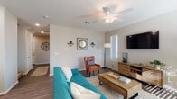 This two-story home offers a thoughtfully designed layout with modern finishes and comfortable living spaces across both levels. The open living area features wood-look flooring, a ceiling fan, and ample natural light filtering through slatted blinds, creating a warm and inviting atmosphere. The adjacent dining area benefits from a large window overlooking greenery, enhancing the sense of connection to the outdoors. The kitchen is well-equipped with white shaker cabinetry, granite countertops, stainless steel appliances, recessed lighting, and a center island with a double sink — ideal for both everyday cooking and entertaining. The bedrooms are carpeted for comfort; the primary suite includes a ceiling fan, multiple windows, and access to a spacious walk-in closet with built-in shelving. Secondary bedrooms are cozy and well-lit. The bathrooms are finished with granite-topped vanities, wood-look tile flooring, and glass-enclosed showers. The primary bath features a dual-sink vanity with generous counter space. Throughout the home, a neutral color palette and consistent use of quality materials contribute to a cohesive, contemporary aesthetic that is both functional and visually appealing.