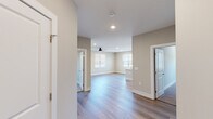 This single-story home at 214 Oakwood Ave NE in Huntsville, Alabama presents a clean, modern design with a neutral color palette and consistent finishes throughout. The interior is characterized by warm-toned walls, white trim, and recessed lighting that creates a bright, welcoming atmosphere across all rooms.

The open living area features light wood-look flooring, a ceiling fan, and multiple windows fitted with white blinds that allow natural light to fill the space. The layout flows naturally between rooms, with clearly defined doorways connecting each area.

The kitchen is well-appointed with rich dark wood cabinetry, stainless steel appliances including a refrigerator, electric range, and microwave, all complemented by a white quartz peninsula countertop with an undermount sink. Pendant lighting above the peninsula adds a stylish touch, while generous windows provide natural light and ventilation.

The bedrooms offer plush carpeting, ceiling fans, and ample natural light from well-placed windows. One room features light wood-look flooring, maintaining the cohesive aesthetic of the home.

The bathrooms are finished with wood-toned vanities, white quartz countertops, undermount sinks, and wood-look tile flooring. Each bathroom is clean and functional, with one featuring a framed mirror and the other a dedicated shower area with a chrome grab bar.