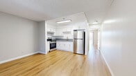 Located at 2701 Randolph St in Huntington Park, CA, this one-bedroom, one-bathroom unit offers a well-organized layout across a single floor. Light wood laminate flooring runs consistently throughout the space, creating a clean and cohesive look.

The living room serves as the entry point, featuring a wall-mounted air conditioning unit, a large window with vertical blinds, and a textured ceiling. The open kitchen is efficiently designed with white shaker cabinetry, gray quartz-style countertops, and stainless steel appliances including a range with overhead hood, a full-size refrigerator, and a single-basin sink. A skylight above the kitchen adds natural light to the cooking area.

The bedroom is a well-proportioned private retreat featuring a sliding glass door that opens to a balcony overlooking mature trees, allowing abundant natural light to fill the room. A full-width sliding closet provides practical storage. The bathroom is cleanly finished with a white vanity cabinet, gray countertop, undermount sink, and wood flooring consistent with the rest of the unit.

Overall, the unit presents a freshly updated interior with a neutral color palette, modern fixtures, and functional use of space throughout.