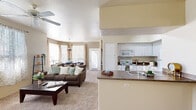 This single-story, 3-bedroom, 2-bathroom home in Phoenix, Arizona offers a practical and comfortable layout designed for everyday living. The open-concept main area seamlessly connects the living room, dining room, and kitchen, creating a cohesive and functional space. The living room features plush carpeting, a ceiling fan, and large windows with sheer curtains that invite abundant natural light and outdoor views. The adjacent dining area benefits from floor-to-ceiling windows, further brightening the space. The kitchen is well-equipped with white cabinetry, a full suite of appliances including a range, microwave, and refrigerator, tile flooring, and a peninsula with a sink that overlooks the living area. The primary bedroom is a comfortable retreat with a ceiling fan, dual windows, and soft carpet. The two additional bedrooms are similarly appointed with natural light and carpeted floors. Both bathrooms feature tile flooring and white vanities; one includes a tub-shower combination. Additional highlights include two closets, a dedicated laundry area, and a private patio — ideal for enjoying Arizona's outdoor lifestyle.