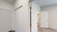 Located at 1882 Fox Rd in Rapid City, South Dakota, this three-bedroom, two-bathroom single-story home offers a well-designed layout across a comfortable footprint. The open kitchen and living area serves as the heart of the home, featuring dark espresso cabinetry with sleek hardware, marble-style countertops, wood-look flooring, recessed lighting, and a full suite of black appliances including a refrigerator, range, and over-the-range microwave. The living area connects to a private balcony through sliding glass doors, bringing in natural light and offering outdoor access with views of the surrounding community. Each of the three bedrooms is carpeted for warmth and comfort, with the primary bedroom providing generous space and its own dedicated closet. Additional closets throughout the unit offer ample storage, including a spacious walk-in closet with full-length hanging rods and shelving. The hallways are finished with clean white six-panel doors and vaulted ceiling accents. Both bathrooms are cleanly appointed with dark vanity cabinetry, marble-style countertops, and full tub-shower combos. The home's neutral color palette and modern finishes create a bright, move-in-ready atmosphere throughout.