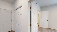 Located at 1882 Fox Rd in Rapid City, South Dakota, this three-bedroom, two-bathroom single-story home offers a well-designed layout across a comfortable footprint. The open kitchen and living area serves as the heart of the home, featuring dark espresso cabinetry with sleek hardware, marble-style countertops, wood-look flooring, recessed lighting, and a full suite of black appliances including a refrigerator, range, and over-the-range microwave. The living area connects to a private balcony through sliding glass doors, bringing in natural light and offering outdoor access with views of the surrounding community. Each of the three bedrooms is carpeted for warmth and comfort, with the primary bedroom providing generous space and its own dedicated closet. Additional closets throughout the unit offer ample storage, including a spacious walk-in closet with full-length hanging rods and shelving. The hallways are finished with clean white six-panel doors and vaulted ceiling accents. Both bathrooms are cleanly appointed with dark vanity cabinetry, marble-style countertops, and full tub-shower combos. The home's neutral color palette and modern finishes create a bright, move-in-ready atmosphere throughout.