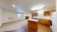 Located at 4723 Southridge Ct in Eau Claire, Wisconsin, this well-appointed 2-bedroom, 1-bathroom single-floor home offers a thoughtfully designed layout with a comfortable, functional feel throughout. The heart of the home is an open-concept kitchen and living area, where warm oak cabinetry, a center island with white countertops, and hardwood-style flooring define the kitchen space. Appliances include a range, dishwasher, and refrigerator. The kitchen flows seamlessly into the carpeted living room, which features a fireplace and a window that brings in natural light. Both bedrooms are carpeted and generously sized, each equipped with double closet doors for ample storage. The primary bedroom offers a comfortable retreat with its own closet and ceiling fan. The full bathroom features hardwood-style flooring, a single-sink vanity with storage, and clean, neutral finishes. In-unit laundry adds everyday convenience. With five closets total, storage is plentiful throughout. A private balcony with a white-railed deck overlooks a landscaped yard dotted with mature evergreen trees, providing a peaceful outdoor escape. This home combines practical living with a warm, inviting atmosphere.