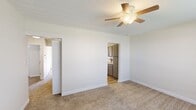 Located at 1806 Runnymead Ave SW in Decatur, Alabama, this single-floor home offers four bedrooms and two full bathrooms within a practical and well-organized layout. The living areas feature neutral-toned carpet and textured ceilings, with ceiling fans installed throughout to promote comfort and air circulation.

Each bedroom is carpeted and includes a louvered bifold closet door providing ample storage. Natural light enters through blinded windows, giving the rooms a bright and airy feel. The primary bedroom is generously sized and offers a comfortable retreat within the home.

The galley-style kitchen is efficiently designed with gray cabinetry lining both walls, light-toned countertops, a stainless steel sink with a modern pull-down faucet, and white appliances including a coil-burner electric range, over-the-range microwave, and refrigerator. The kitchen features wood-look flooring that extends into the hallways, creating a clean transition between spaces.

The bathrooms are finished with wood-look flooring, light countertops, and understated fixtures. One bathroom includes a full tub-shower combination with brushed nickel hardware, while the other features a wide vanity with cabinet storage beneath and a well-lit mirror above.

Three hallways connect the rooms throughout the home, contributing to an intuitive and functional flow across the entire floor plan.
