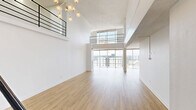 Located on the 15th floor at 800 Pennsylvania St in Denver's Capitol Hill neighborhood, this two-level residence offers an impressive sense of scale across two distinct floors. The lower level features a spacious open-plan living and kitchen area anchored by a distinctive tiled column and floor-to-ceiling windows that frame sweeping panoramic views of the Denver skyline. The kitchen is well-appointed with white shaker cabinetry, quartz countertops featuring subtle veining, a mosaic tile backsplash, dark hardware accents, and stainless steel appliances. A stylish multi-globe chandelier adds an elegant touch to the upper living level, which is accessible via a modern staircase with a sleek black metal railing. Light wood-tone flooring flows consistently throughout both levels, enhancing the bright, airy ambiance. The bedroom is a calm retreat with access to a dedicated walk-in closet featuring built-in shelving. Three bathrooms include tub-shower combinations finished with large-format neutral tiles. Additional closet storage, multiple hallways, and two living areas provide flexible functionality. Natural light is abundant throughout, with sliding door access to outdoor areas and windows in key rooms. The overall aesthetic is clean, modern, and move-in ready.