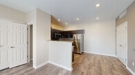 Located at 1003 Meadow Ln in Canonsburg, PA, this single-floor, three-bedroom, two-bathroom home offers a well-designed layout with a comfortable and functional feel throughout. The open-concept living and kitchen area is anchored by a peninsula with granite countertops, providing both workspace and casual seating. The kitchen is well-appointed with dark espresso cabinetry, a tile backsplash, and a full suite of stainless steel appliances, including a refrigerator, range, and microwave. Recessed lighting illuminates the space, which features warm hardwood-style flooring that flows throughout the main living areas. A central hallway with matching flooring connects the bedrooms and bathrooms, maintaining a cohesive aesthetic. The bedrooms are carpeted for comfort, with neutral warm-toned walls and natural light from windows fitted with blinds. One bedroom includes a ceiling fan and a dedicated closet with built-in shelving. The bathrooms echo the kitchen's design language, featuring dark vanity cabinetry topped with granite countertops and durable wood-look flooring. The overall ambiance is clean, modern, and move-in ready, making this a practical and attractive home in a residential Canonsburg setting.