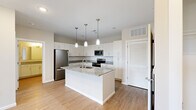 Located at 136 Lemon Dr in Lake Saint Louis, MO, this well-appointed one-bedroom, one-bathroom residence offers a thoughtfully designed single-floor layout. The kitchen serves as a standout centerpiece, featuring white shaker cabinetry, granite countertops, a subway tile backsplash, a large center island with an undermount sink, and stainless steel appliances including a refrigerator, range, microwave, and dishwasher. Three pendant lights hang above the island, adding both style and function. Light wood-style flooring flows throughout the main living areas, complementing the neutral color palette. The living room is bright and airy, with a ceiling fan, natural light from dual windows, and direct access to a private balcony with outdoor views. The bedroom offers plush carpeting, a ceiling fan, and access to a dedicated closet. The bathroom is finished with a granite-topped vanity, wood-style flooring, and a glass-enclosed tiled shower. A dedicated in-unit laundry area with a top-loading washer provides added convenience. Clean lines, modern finishes, and a cohesive neutral palette give this residence a fresh, move-in-ready appeal.