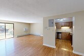 This 2-bedroom, 1-bathroom residence offers a practical and comfortable single-floor layout designed to maximize everyday living. Warm hardwood flooring flows consistently throughout the space, complementing the neutral beige tones on the walls and textured ceilings to create a cohesive, inviting ambiance.

The open-concept living and dining area is generously sized, filled with natural light, and features baseboard heating and a wall-mounted air conditioning unit for year-round comfort. A pass-through window connects the living area to the kitchen, enhancing the sense of openness. The kitchen is well-equipped with stainless steel appliances — including a refrigerator, dishwasher, and range — warm wood cabinetry, light countertops, and an under-cabinet sink. An adjacent pantry provides additional storage.

Both bedrooms are comfortably proportioned, each featuring hardwood floors, baseboard heating, and windows that invite natural light and views of the surrounding greenery. The primary bedroom includes a wall-mounted AC unit and a dedicated closet. The full bathroom is cleanly appointed with a tub/shower combination, a white vanity, and a large mirror.

The unit also benefits from four closets throughout, providing ample storage. Outside, a charming landscaped courtyard with mature trees and manicured shrubs offers a serene setting.