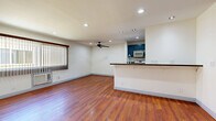 Located in the North Hollywood neighborhood of Los Angeles, this single-story 2-bedroom, 2-bathroom home offers a functional and comfortable layout. Rich hardwood flooring flows throughout the living areas and bedrooms, creating a warm and cohesive atmosphere. The living room is a well-proportioned space featuring recessed lighting, a ceiling fan, and vertical blinds over a large window that allows natural light to fill the room. An entry area provides a welcoming transition into the home, with a double-door closet offering convenient storage.

The galley-style kitchen is outfitted with distinctive slate-blue cabinetry, dark granite countertops, a gas range, and a stainless steel refrigerator, all set atop light ceramic tile flooring. Both bedrooms feature warm hardwood floors, ceiling fans, and windows with neighborhood views. The primary bedroom includes a mirrored sliding-door closet, while the second bedroom also benefits from recessed lighting.

The two bathrooms are finished with large-format beige tile on the floors and walls, each featuring a glass-enclosed shower and tub combination with chrome fixtures and mirrored medicine cabinets, providing a clean and practical design throughout.