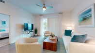 Located at 3680 46th Ave S in Saint Petersburg, Florida, this single-floor residence offers a clean, contemporary design with a bright coastal aesthetic. The open-concept layout seamlessly connects the kitchen, dining, and living areas, creating a spacious and functional flow. Light wood-style flooring runs throughout the main living spaces, complementing the white walls and abundant natural light.

The kitchen is a standout feature, outfitted with sleek white cabinetry, quartz countertops, a white subway tile backsplash, and a full suite of stainless steel appliances including a range, microwave, dishwasher, and French door refrigerator. A large central island with pendant lighting and bar seating makes it ideal for both cooking and entertaining.

The living room is airy and inviting, with a ceiling fan, floor-to-ceiling vertical blinds, and sliding glass door access to an outdoor area. Coastal-inspired décor in teal and white tones enhances the relaxed ambiance.

The bedrooms are carpeted and well-lit by large windows, offering a peaceful retreat. The bathroom features a dual-sink vanity with white cabinetry, quartz countertops, and large-format tile flooring. Overall, this residence delivers a polished, modern living experience in a bright and cohesive coastal style.