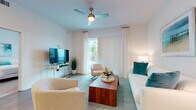 Located at 3680 46th Ave S in Saint Petersburg, Florida, this single-floor residence offers a clean, contemporary design with a bright coastal aesthetic. The open-concept layout seamlessly connects the kitchen, dining, and living areas, creating a spacious and functional flow. Light wood-style flooring runs throughout the main living spaces, complementing the white walls and abundant natural light.

The kitchen is a standout feature, outfitted with sleek white cabinetry, quartz countertops, a white subway tile backsplash, and a full suite of stainless steel appliances including a range, microwave, dishwasher, and French door refrigerator. A large central island with pendant lighting and bar seating makes it ideal for both cooking and entertaining.

The living room is airy and inviting, with a ceiling fan, floor-to-ceiling vertical blinds, and sliding glass door access to an outdoor area. Coastal-inspired décor in teal and white tones enhances the relaxed ambiance.

The bedrooms are carpeted and well-lit by large windows, offering a peaceful retreat. The bathroom features a dual-sink vanity with white cabinetry, quartz countertops, and large-format tile flooring. Overall, this residence delivers a polished, modern living experience in a bright and cohesive coastal style.