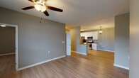 This single-story residence in Mandeville, Louisiana, offers a well-designed layout with three bedrooms and two full bathrooms. Light wood-look flooring runs consistently throughout the home, contributing to a cohesive and contemporary aesthetic complemented by neutral gray wall tones and crisp white trim.

The open-concept living area is spacious and airy, with a ceiling fan overhead and natural light entering through windows with views of the surrounding area. This space flows directly into the kitchen, which is a standout feature of the home. The kitchen is equipped with stainless steel appliances, including a gas range, built-in microwave, and refrigerator. White shaker-style cabinetry provides ample storage, while granite countertops add a refined touch. A peninsula with pendant lighting and a chandelier accent define the dining area.

A central hallway connects the bedrooms and bathrooms, maintaining an efficient and functional floor plan. The bathrooms are finished with clean, simple fixtures, including a tub/shower combination in one. A dedicated laundry area houses a full-size washer and dryer with overhead cabinetry for additional storage. The overall ambiance is clean, modern, and move-in ready.