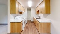Located in Vancouver, Washington, this 2-bedroom, 1-bathroom unit offers a well-organized single-floor layout designed for comfortable everyday living. The galley-style kitchen is a functional highlight, featuring light maple cabinetry on both sides, white countertops, a stainless steel sink, a white electric range, and a full-size refrigerator. Wood-look laminate flooring runs through the kitchen and flows into the combined dining and living area, which is brightened by a window with views of surrounding greenery and includes a wall-mounted mini-split system for year-round climate control. Both bedrooms are carpeted and finished with neutral tones, each featuring sliding or hinged closet doors for dedicated storage. Natural light enters each bedroom through windows overlooking lush outdoor foliage, creating a calm and restful atmosphere. The bathroom is neatly appointed with a light maple vanity, white countertop, a wall-mounted medicine cabinet, an accessibility grab bar, and tile-look flooring. Throughout the unit, clean white walls, consistent wood-toned trim, and recessed or flush-mount lighting contribute to a cohesive, modern aesthetic. Five closets provide generous storage throughout the space.