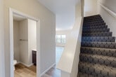 Located at 127 Estes Dr in Saint Peters, MO, this three-floor home offers 3 bedrooms, 4 bathrooms, and a well-organized layout across its levels. Light wood-look flooring flows throughout the main living areas, complemented by neutral wall tones that create a clean, cohesive aesthetic. The combined kitchen and dining area serves as the heart of the home, featuring granite countertops, a central island with a built-in sink, white shaker-style cabinetry, a subway tile backsplash, and stainless steel appliances. The dining space adjoins the kitchen and is brightened by a large window with outdoor views and an elegant chandelier overhead. Carpeted stairs with a distinctive honeycomb pattern connect the floors, leading to three well-proportioned bedrooms. The spacious primary bedroom includes a walk-in closet with wire shelving. Four bathrooms—finished with wood-look flooring and dark-toned vanities—serve the home's occupants comfortably. The attached garage features a concrete floor and an automatic opener, with room for a vehicle and additional storage. Below, the unfinished basement presents a generous open area with concrete walls and flooring, offering significant potential for future development or storage use.