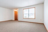 Located at 1013 E Monowau St in Tomah, Wisconsin, this single-story home offers a practical and comfortable layout with 3 bedrooms and 2 bathrooms. The combined kitchen and living room serves as the heart of the home, featuring warm oak cabinetry, a tile-style floor, a kitchen island for additional prep space, and appliances including an electric range, dishwasher, and refrigerator. The open layout allows the living area to flow seamlessly, with carpet underfoot and a large window that brings in natural light and outdoor views. Each of the three bedrooms is carpeted and finished with warm wood-toned trim and doors, providing a consistent and cohesive aesthetic. The primary bedroom offers generous proportions, while the additional bedrooms each include closet space. The home is notably well-equipped with a total of eight closets, offering exceptional storage throughout. The two bathrooms are finished with tile flooring, wood-trimmed vanities, and updated light fixtures. A central hallway connects the bedroom wing efficiently. The attached garage features an automatic opener and provides ample room for parking and additional storage. Textured ceilings and warm wood baseboards and door trim are consistent design elements found throughout the home.