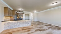 Located at 182 Delano Dr in Chambersburg, PA, this two-story home offers five bedrooms and two bathrooms thoughtfully distributed across two well-proportioned floors. The main level features an open-concept kitchen and living area finished with light wood-look tile flooring and elegant crown molding. The kitchen is highlighted by a striking stone-faced island with dark granite countertops, warm taupe cabinetry, a tile backsplash, and stainless steel appliances. A dedicated pantry with wire shelving provides ample storage. The living area benefits from natural light through a large window with neighborhood views. A carpeted staircase with a classic wood banister connects the two floors via a clean, light-filled hallway. Upstairs, the generously sized primary bedroom features a tray ceiling, plush carpet, and a multi-pane window that fills the room with natural light. A spacious walk-in closet with wire shelving serves the primary suite. The upper level also includes a full bathroom with a tub-shower combination and granite-topped vanity. A dedicated laundry room with built-in shelving, utility sink, and washer/dryer hookups adds everyday convenience. Additional bedrooms offer flexible space suitable for various needs. The home's neutral palette and modern finishes create a clean, move-in ready aesthetic throughout.