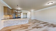 Located at 182 Delano Dr in Chambersburg, PA, this two-story home offers five bedrooms and two bathrooms thoughtfully distributed across two well-proportioned floors. The main level features an open-concept kitchen and living area finished with light wood-look tile flooring and elegant crown molding. The kitchen is highlighted by a striking stone-faced island with dark granite countertops, warm taupe cabinetry, a tile backsplash, and stainless steel appliances. A dedicated pantry with wire shelving provides ample storage. The living area benefits from natural light through a large window with neighborhood views. A carpeted staircase with a classic wood banister connects the two floors via a clean, light-filled hallway. Upstairs, the generously sized primary bedroom features a tray ceiling, plush carpet, and a multi-pane window that fills the room with natural light. A spacious walk-in closet with wire shelving serves the primary suite. The upper level also includes a full bathroom with a tub-shower combination and granite-topped vanity. A dedicated laundry room with built-in shelving, utility sink, and washer/dryer hookups adds everyday convenience. Additional bedrooms offer flexible space suitable for various needs. The home's neutral palette and modern finishes create a clean, move-in ready aesthetic throughout.