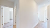 Located at 110 W Hillsdale St in Lansing, Michigan, this single-floor residence offers a clean, contemporary design with a bright and cohesive aesthetic throughout. The open-concept layout seamlessly connects the kitchen and living area, creating a spacious and functional living environment. The kitchen is a standout feature, equipped with stainless steel appliances including a refrigerator, range, and microwave, complemented by crisp white cabinetry, grey quartz-style countertops, a tile backsplash, and a central island with pendant lighting overhead. Light wood-style flooring runs throughout the main living areas, adding warmth to the modern palette. The bedrooms are carpeted for comfort and each benefit from large windows that invite natural light and offer views of the surrounding Lansing cityscape and greenery. The hallway connects the living spaces to the private areas of the unit with clean white walls and consistent flooring. The bathroom is well-appointed with a white vanity, undermount sink, grey countertop, a tub/shower combination, and light wood-style flooring. Recessed lighting throughout the unit enhances the bright, airy ambiance, making this a polished and move-in-ready space in the heart of Lansing.