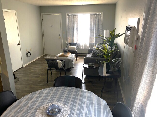 1 dormitorio con comedor y sala de estar - Parkway Village Apartments