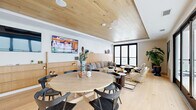 Located at 4055 Elati St in Denver, Colorado, this thoughtfully designed single-floor lounge space offers a warm and inviting atmosphere through a cohesive blend of modern and natural design elements. The space is unified by striking light wood plank ceilings with recessed lighting and matching wide-plank hardwood flooring, creating a seamless, organic aesthetic throughout.

The main lounge area is anchored by a generously sized curved gray sofa set against a floor-to-ceiling wood-paneled accent wall, complemented by dark round side tables, rattan accent chairs, and layered area rugs. A wall-mounted flat-screen television and curated artwork add character to the space. Tall black-framed glass doors flood the room with natural light and open directly onto an outdoor terrace, extending the living experience beyond the interior.

The dining area features a round light wood table surrounded by black sculptural chairs, positioned beneath a tray ceiling detail that adds architectural interest. Adjacent to the dining space is a compact kitchenette, distinguished by a bold geometric patterned tile backsplash, dark marble countertops, pendant lighting, and under-counter refrigeration—ideal for hosting and entertaining.

Lush potted plants and carefully selected décor pieces enhance the overall ambiance, making this a welcoming and functional gathering space in the heart of Denver.
